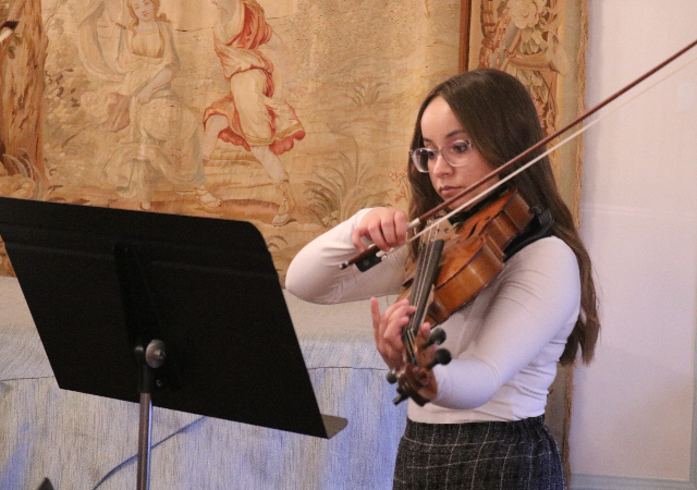 A member of USD Strings playing violin in the French Parlor