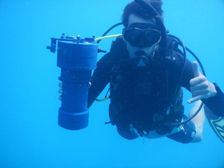 Stephen underwater with a scientific instrument in scuba gear.