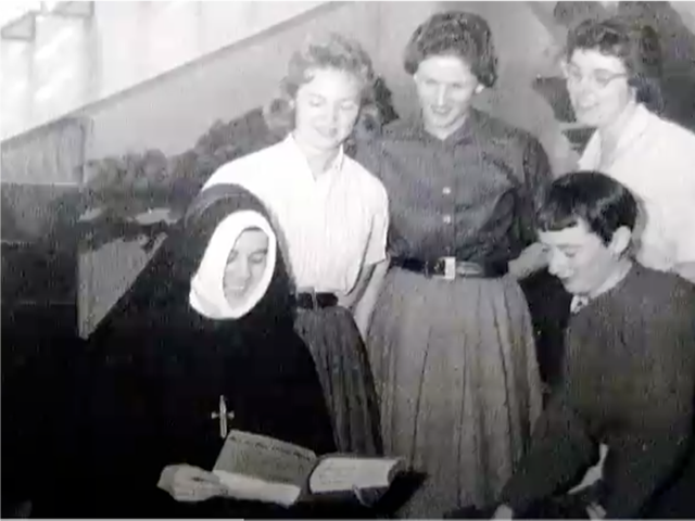 A young Sister Pat Shaffer in a nun habit with students.