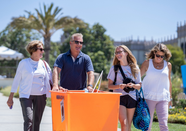 Family members help a first-year student move in to her residence hall.