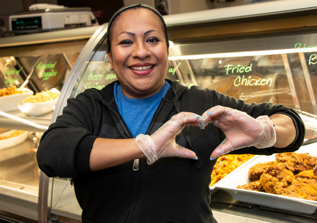 Campus employee making a heart shape with her hands