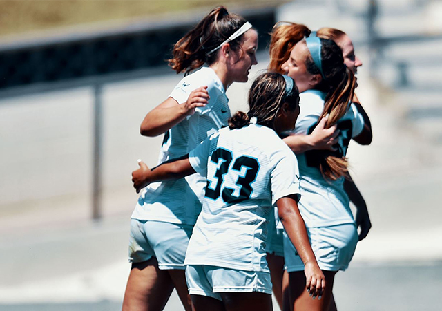 Members of the USD women's soccer team celebrate after a goal in Sunday's 4-0 win over Holy Cross