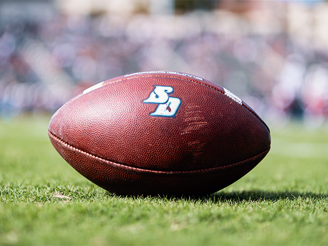football with USD logo on grass at Torero Stadium