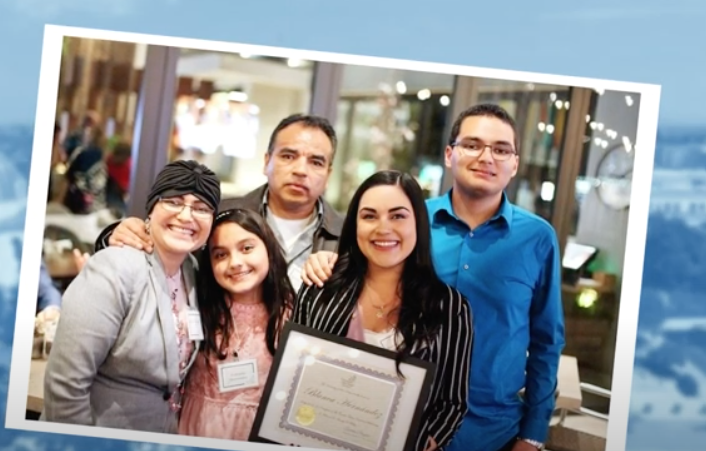 Blanca Hernandez smiles with her family while holding her USD business degree