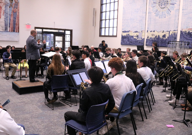 National Catholic Honor Band with conductor inside a classroom