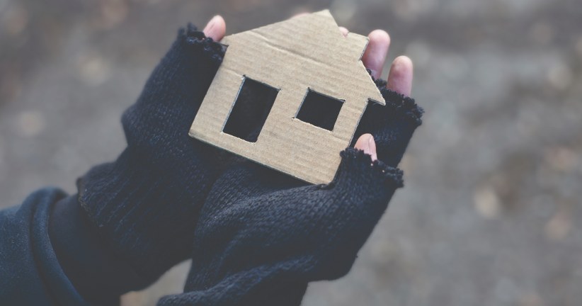 two hands holding a cardboard house