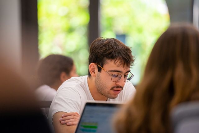 Student sitting in a classroom working on an assignment