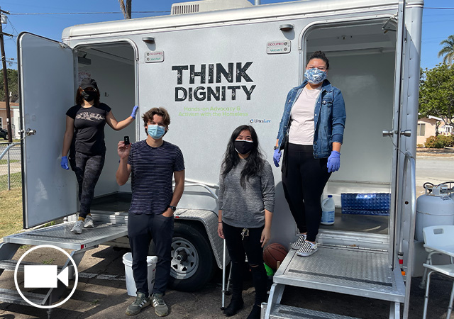 Image of Think Dignity team standing in front of the mobile showers