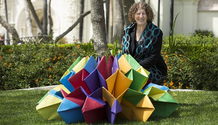 Perla Myers, part of Project VisMo, poses with a large origami piece