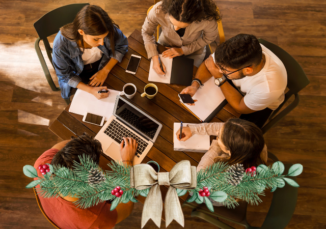 This is a top down picture of five students studying at a table.