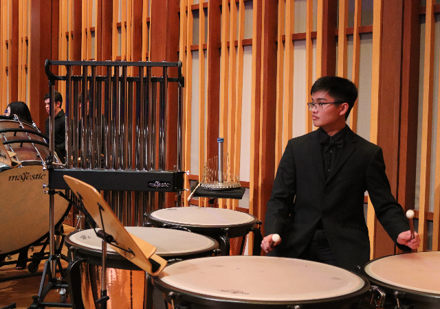 Student playing the timpani on stage