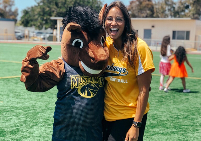 Mary Grabowski shares a light moment with the Mueller Charter School mascot. Grabowski is a PE teacher at the school.
