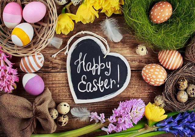 heart-shaped chalkboard with "happy easter" written on it, surrounded by colored eggs