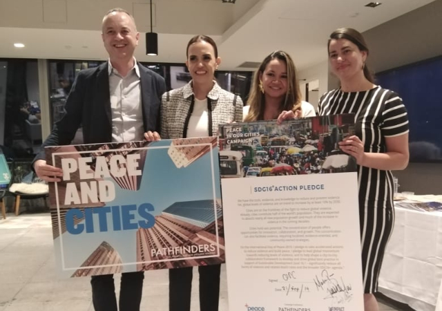 Kroc students holding Peace in our Cities promotional materials