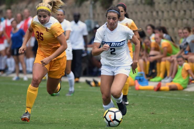 USD women's soccer player dribbling a ball