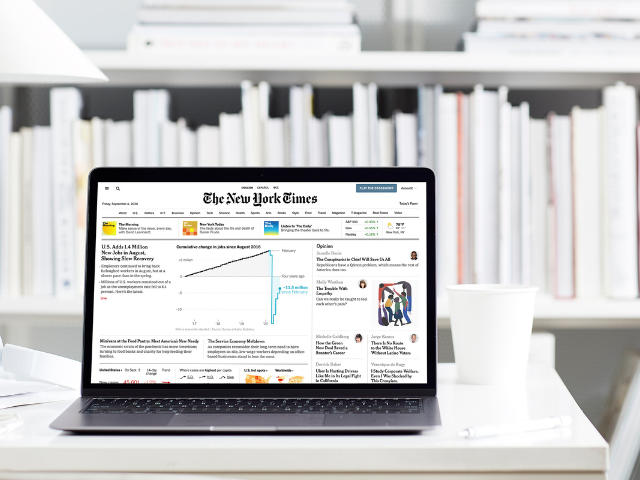 Image of laptop on a desk with NYT home page on the screen