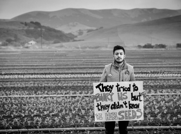 Photograph of immigrant holding a sign