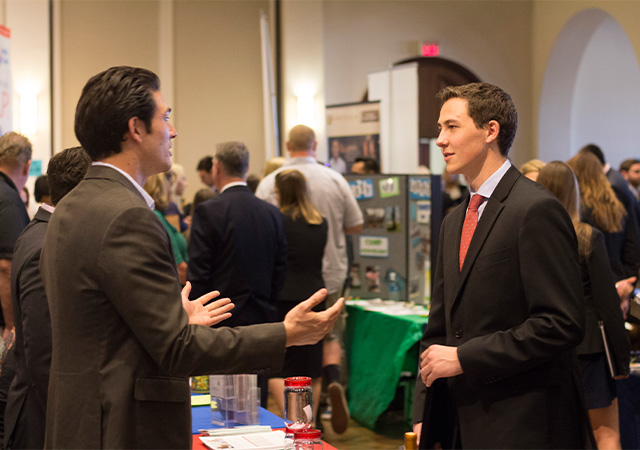 Photo of a student talking to a company representative at the 2016 Career Fair