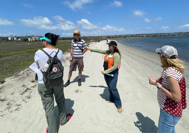 Image of faculty members at the marsh reserve, discussing water justice challenges