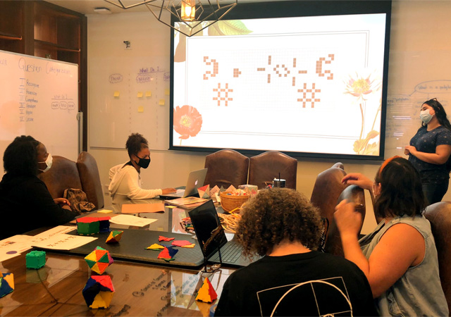 Students and faculty working in a conference room on the MathSpark project