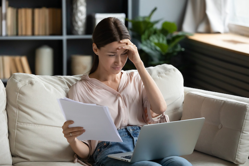 A remote worker sitting in front of a computer looking upset.