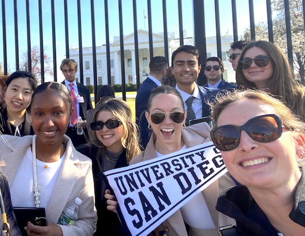 A group of Knauss School of Business graduate accounting students take a picture in front of the White House gates
