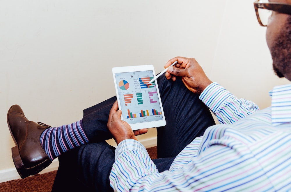 Man looking at marketing analytics on a tablet.
