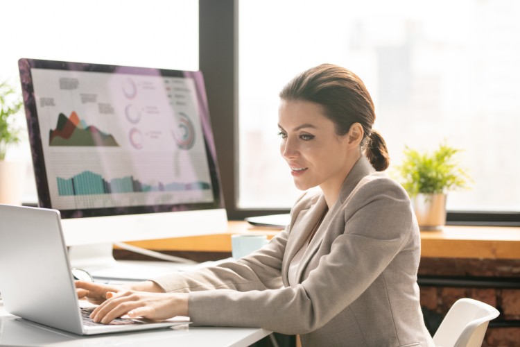 A woman works on a laptop in her office