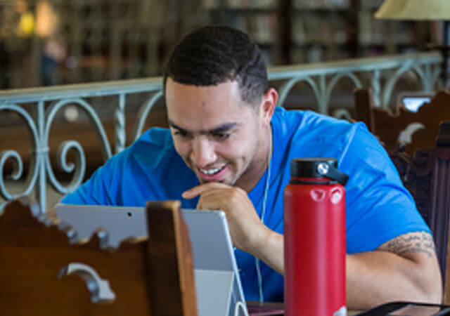 Young Male with tablet at Library Table