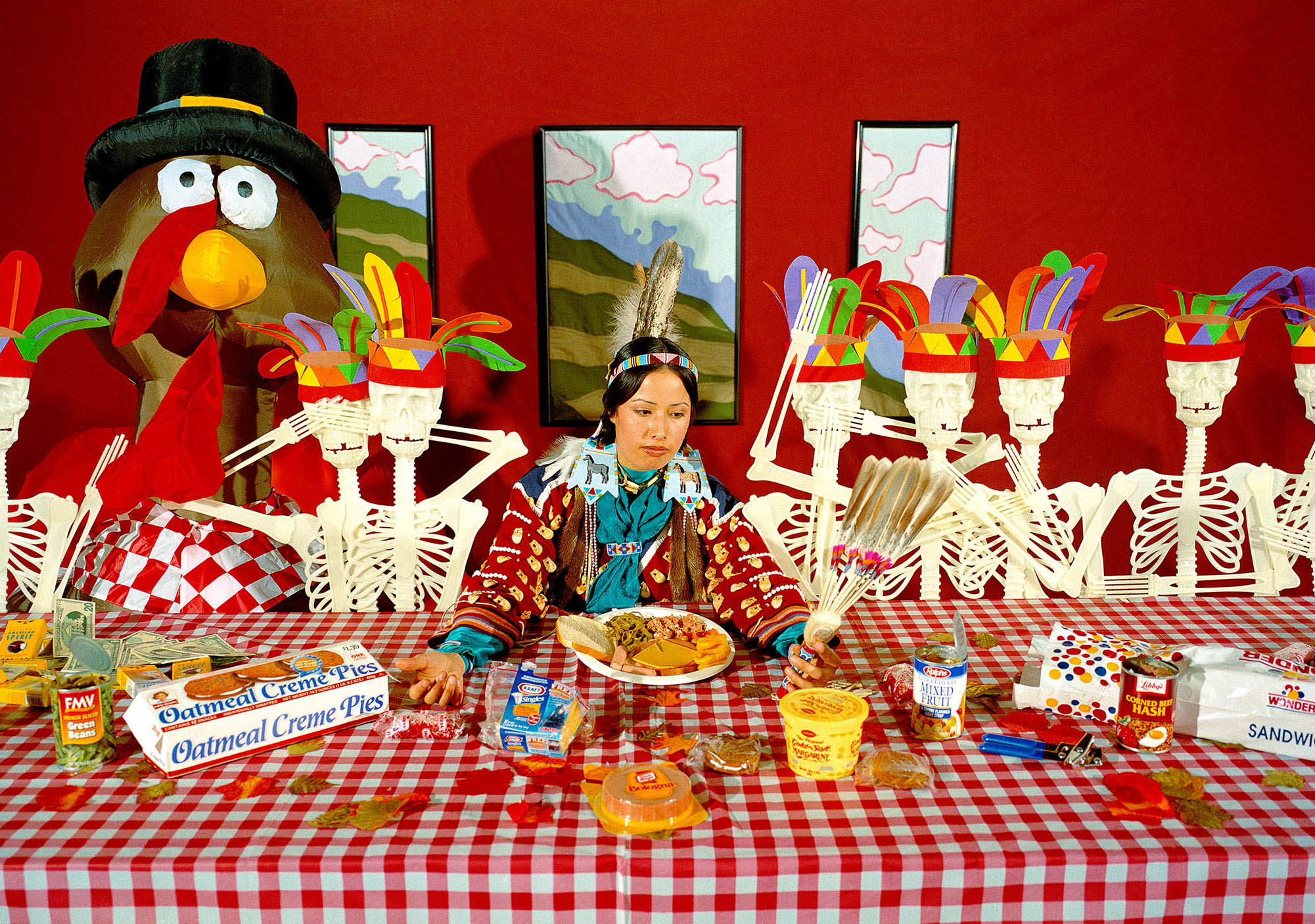 A satirical table-scape of the first Thanksgiving, featuring the artist sitting at center.