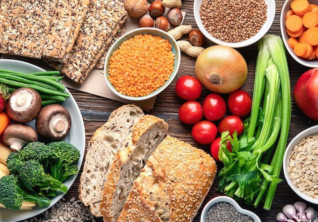 A bountiful assortment of food, including breads, grains, vegetables, and nuts.