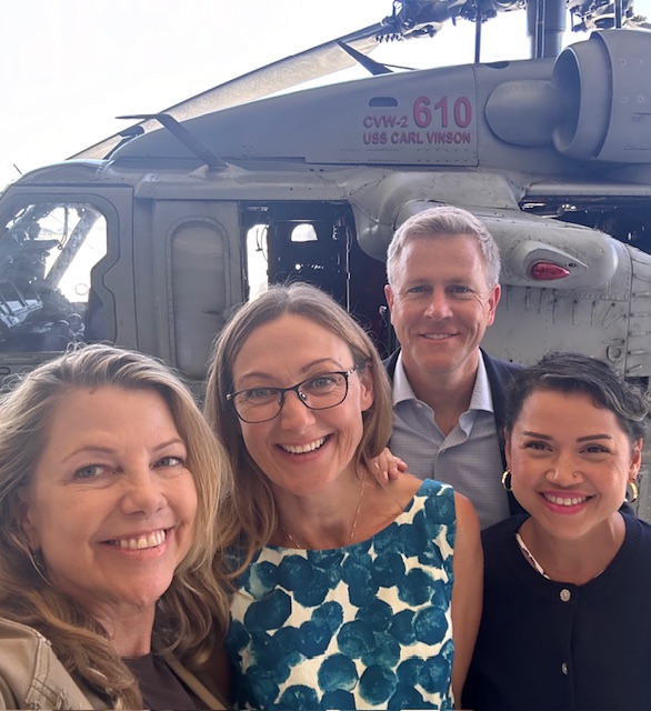 group photo in front of helicopter