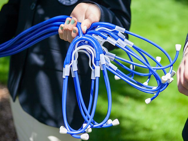 A person holding a bunch of stethoscopes