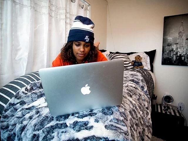 A student studying in her room on the USD campus